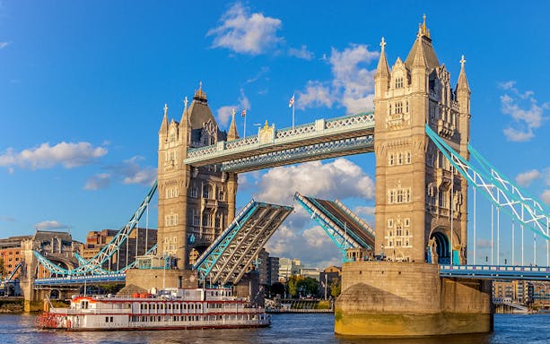 Tower Bridge in London with raised bascules, viewed from the River Thames.