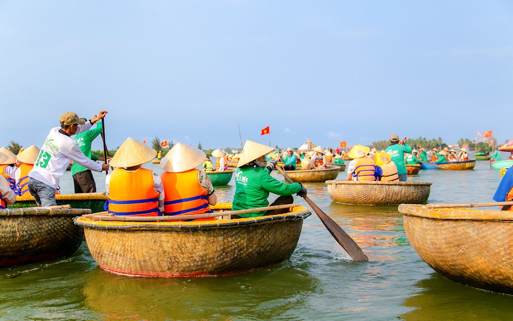 Bamboo basket boats navigating a river in a coconut palm forest tour.
