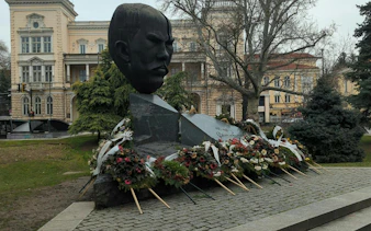 Bust monument with floral tributes in Sofia, part of Sofia Obscura Secrets exploration game.