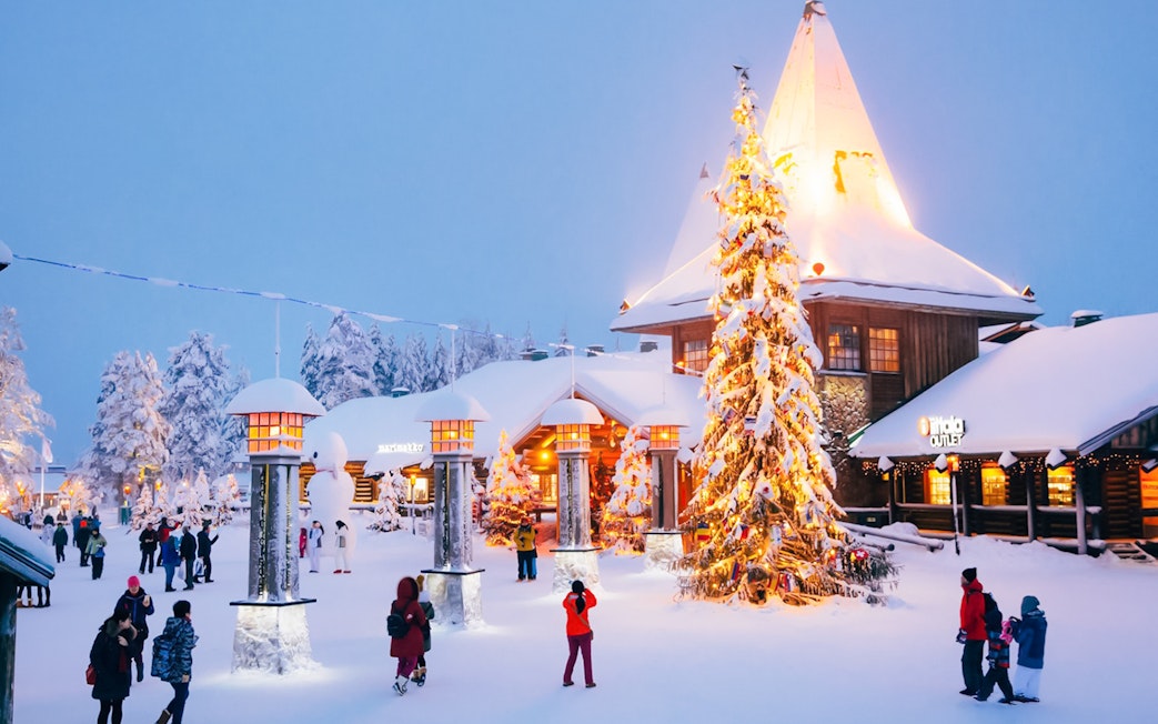 Santa’s Village central plaza with people walking near a decorated Christmas tree.