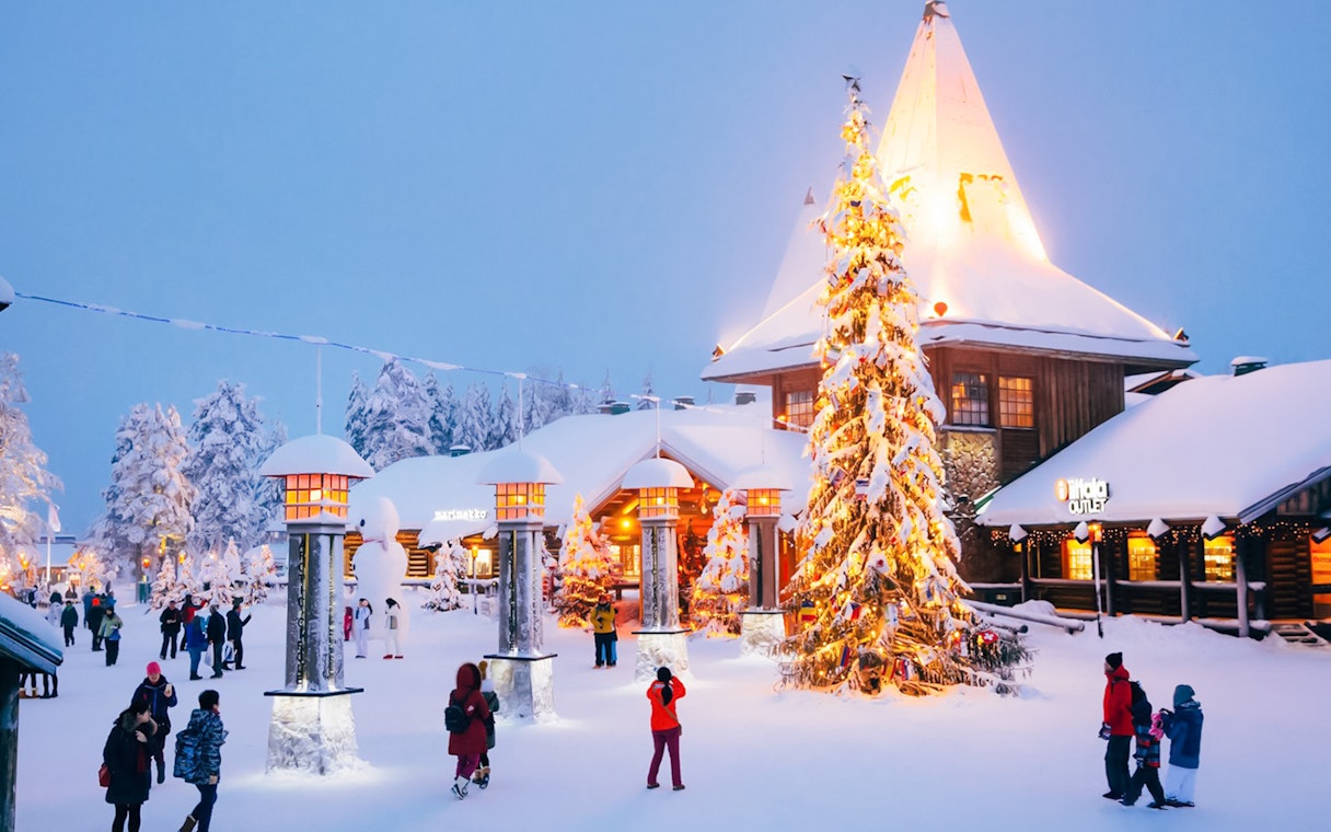 Santa’s Village central plaza with people walking near a decorated Christmas tree.