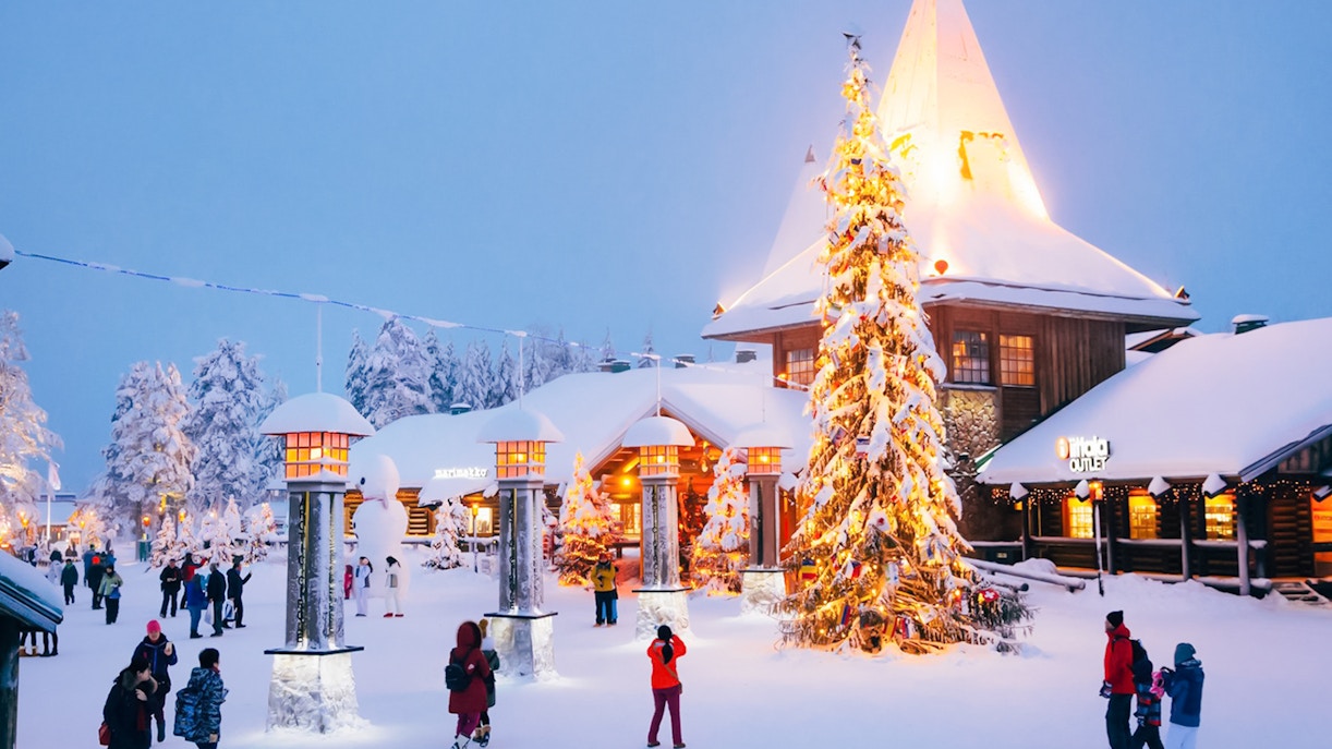 Santa’s Village central plaza with people walking near a decorated Christmas tree.