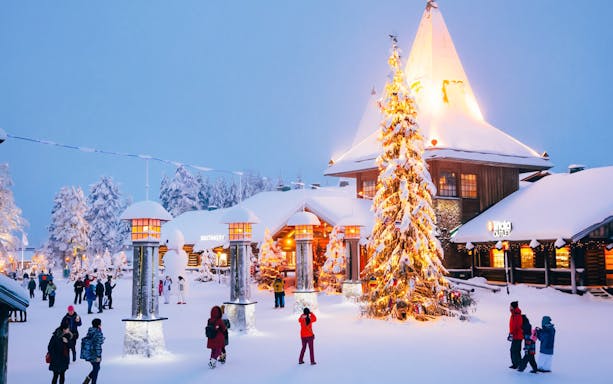 Santa’s Village central plaza with people walking near a decorated Christmas tree.