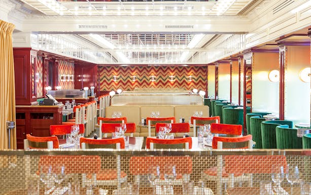 Dining area at Opéra-Grand Café Capucines in Paris with red and green seating.