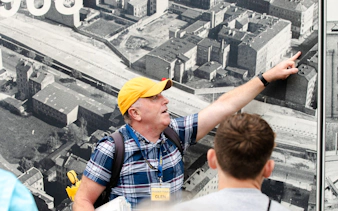 Tour guide pointing at historical Berlin map during Third Reich and Cold War walking tour.