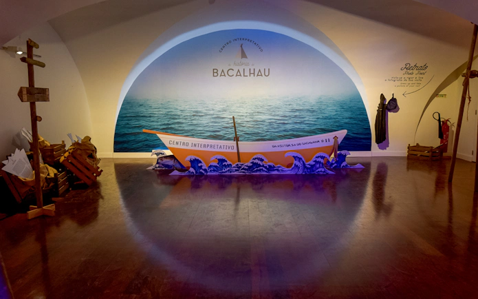Codfish History Interpretation Centre exhibit with boat display and ocean backdrop.