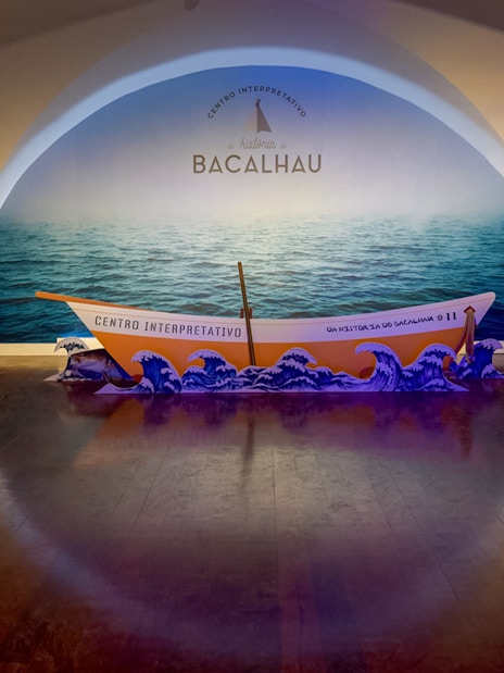 Codfish History Interpretation Centre exhibit with boat display and ocean backdrop.