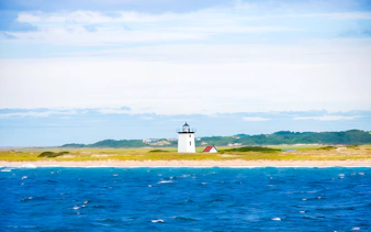 Long Point Lighthouse on sandy shore with ocean in Provincetown, Massachusetts.