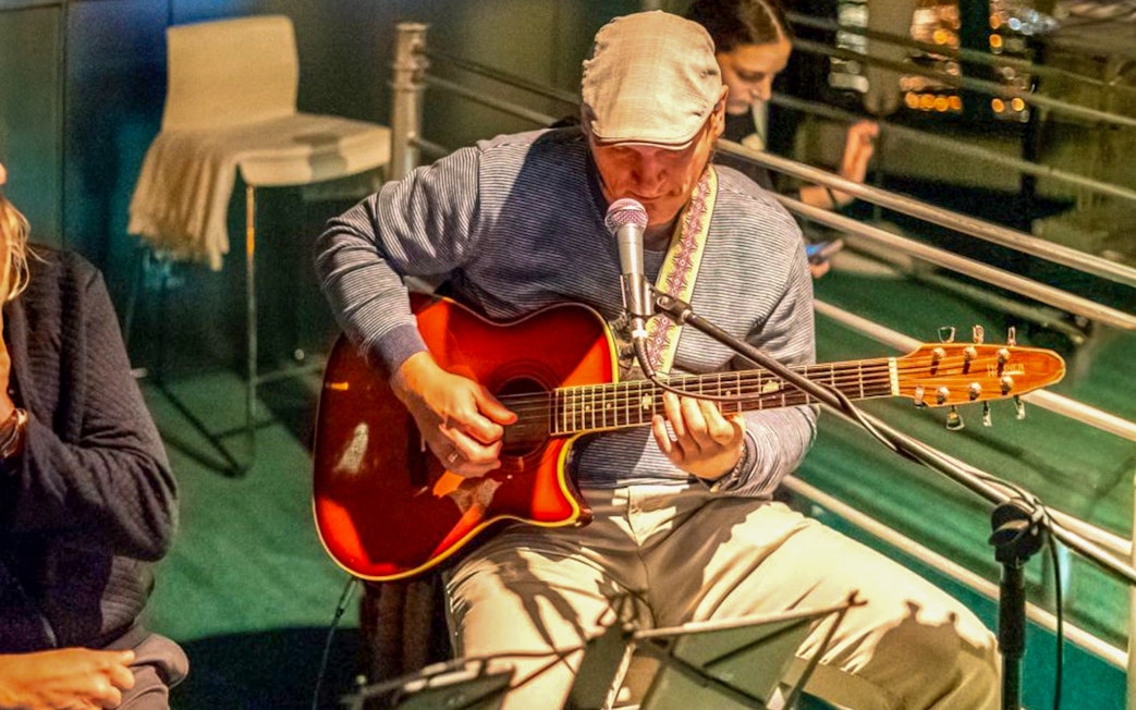 Musician playing guitar during Budapest Candlelit Dinner Cruise.
