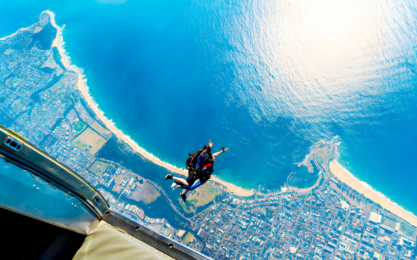 Skydiving instructor and guest tandem jump over Wollongong coastline.