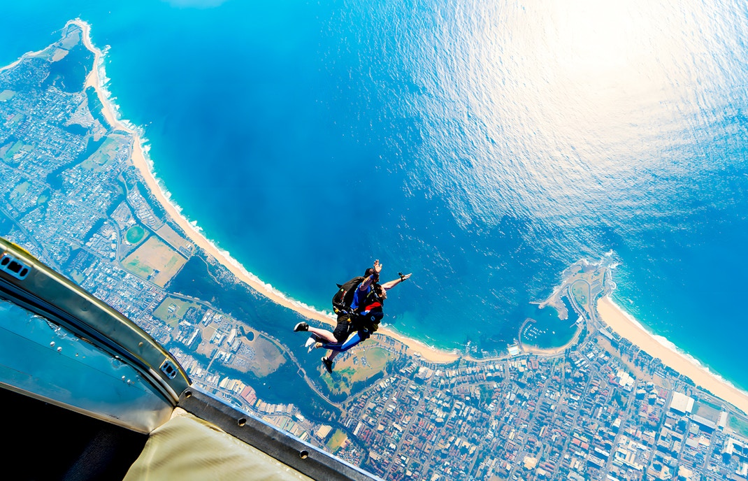 Skydiving instructor and guest tandem jump over Wollongong coastline.