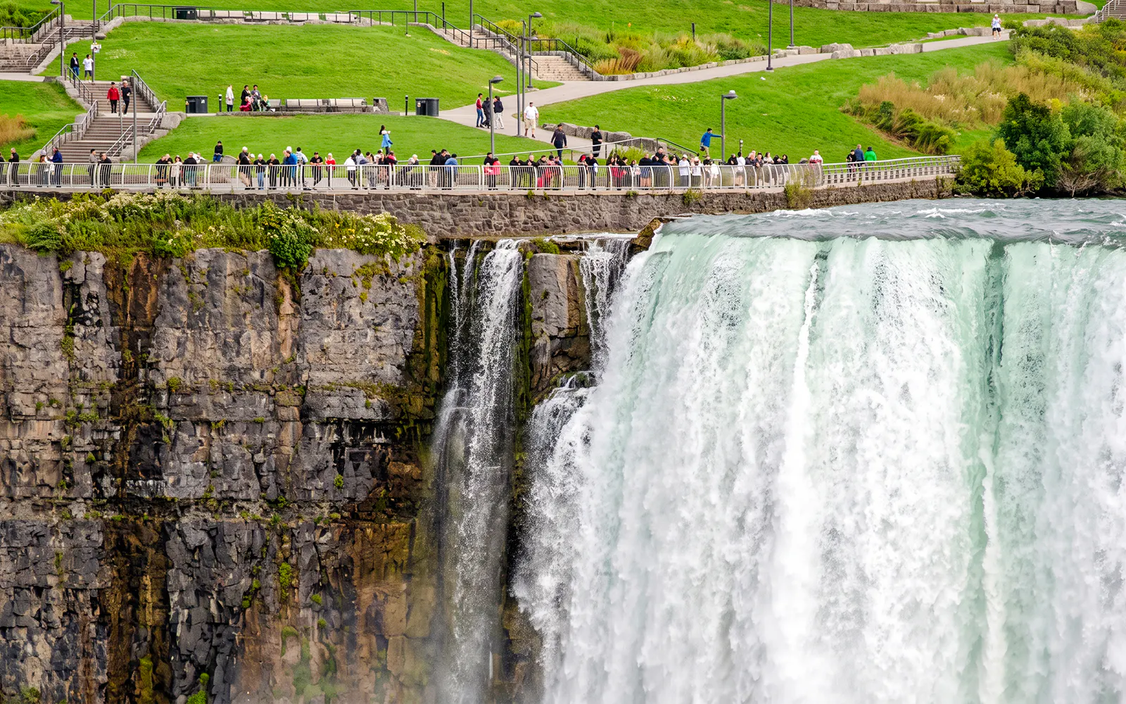 Visitors on a walkway overlooking Niagara Falls during a walking tour with Maid of the Mist and Cave of the Winds.
