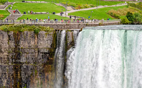 Visitors on a walkway overlooking Niagara Falls during a walking tour with Maid of the Mist and Cave of the Winds.