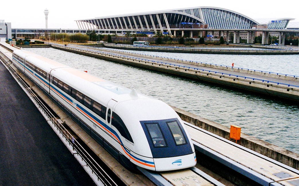 Shanghai Maglev Train traveling near modern station architecture.