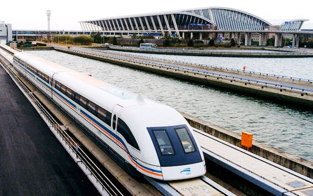 Shanghai Maglev Train traveling near modern station architecture.