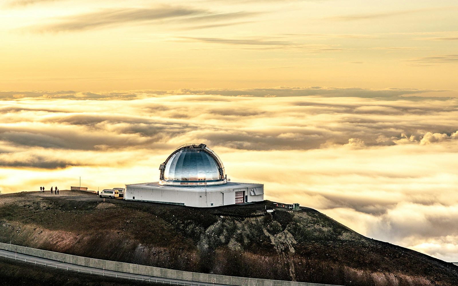 Mauna Kea Observatory dome above clouds at sunset, Hawaii.