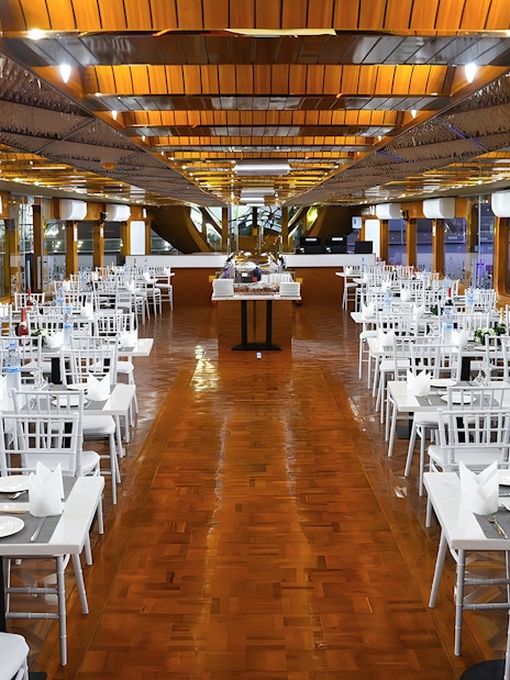 Dining setup on a dhow cruise in Dubai Marina with tables and chairs arranged for dinner.