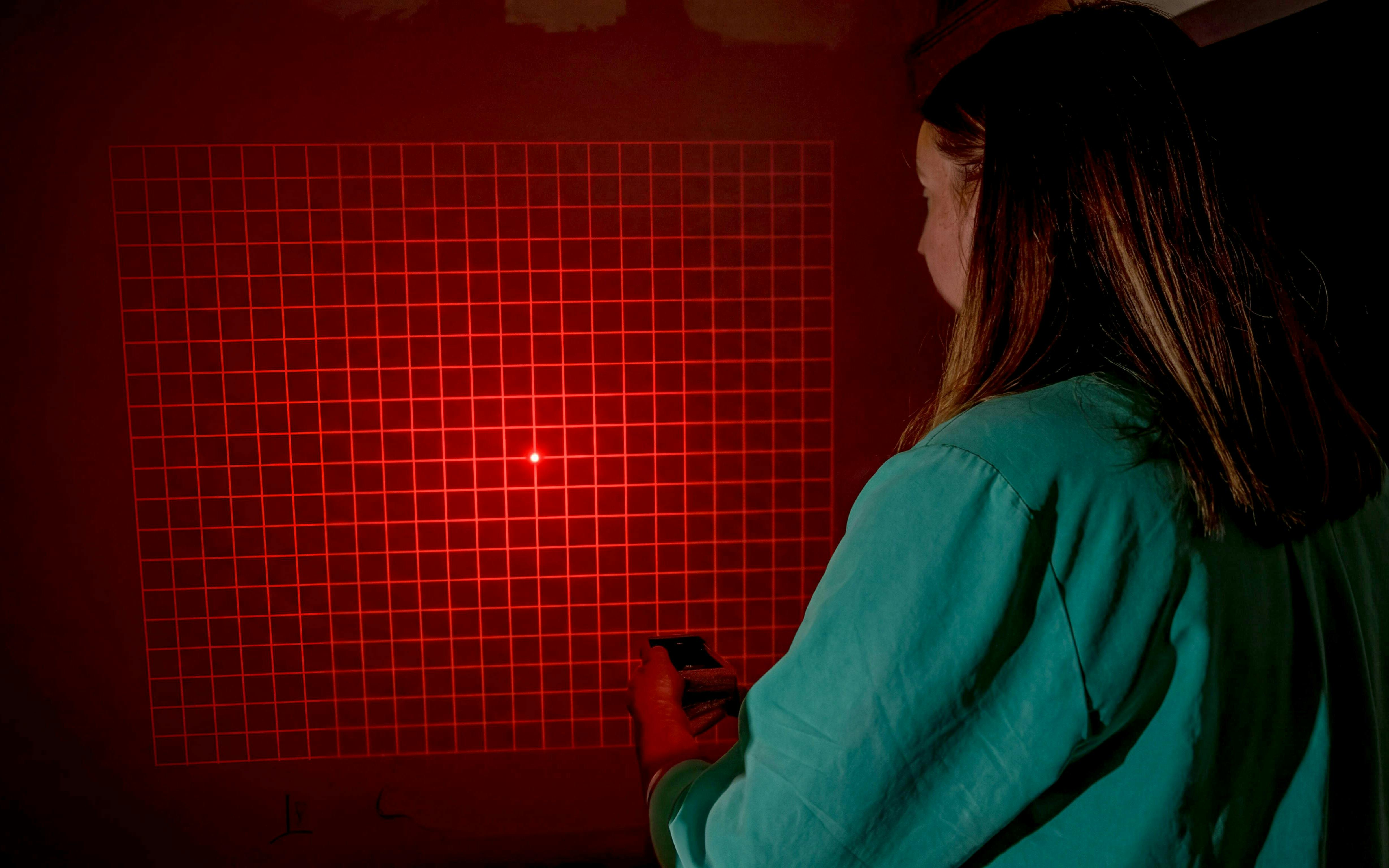 Person using a device to investigate paranormal activity in Savannah with red grid light.
