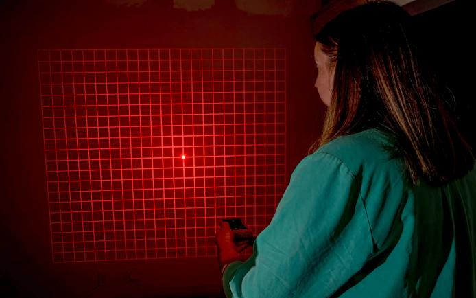Person using a device to investigate paranormal activity in Savannah with red grid light.