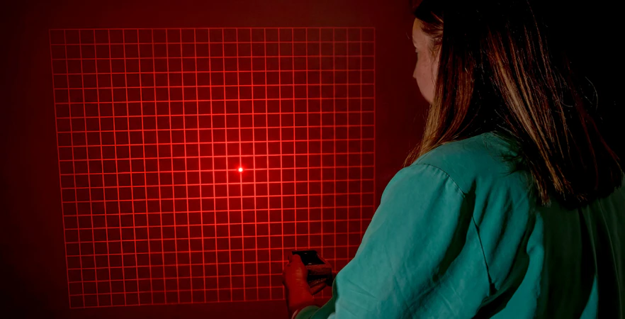 Person using a device to investigate paranormal activity in Savannah with red grid light.