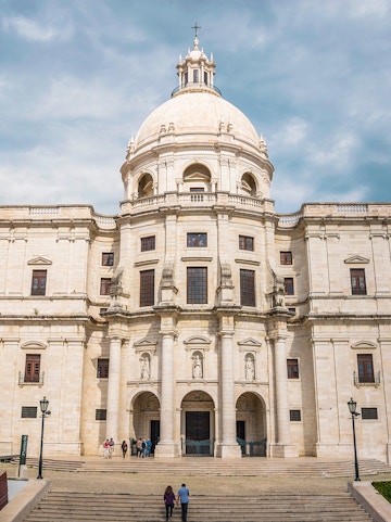 National Pantheon facade in Lisbon with visitors on steps.