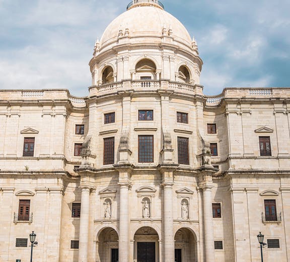 National Pantheon facade in Lisbon with visitors on steps.