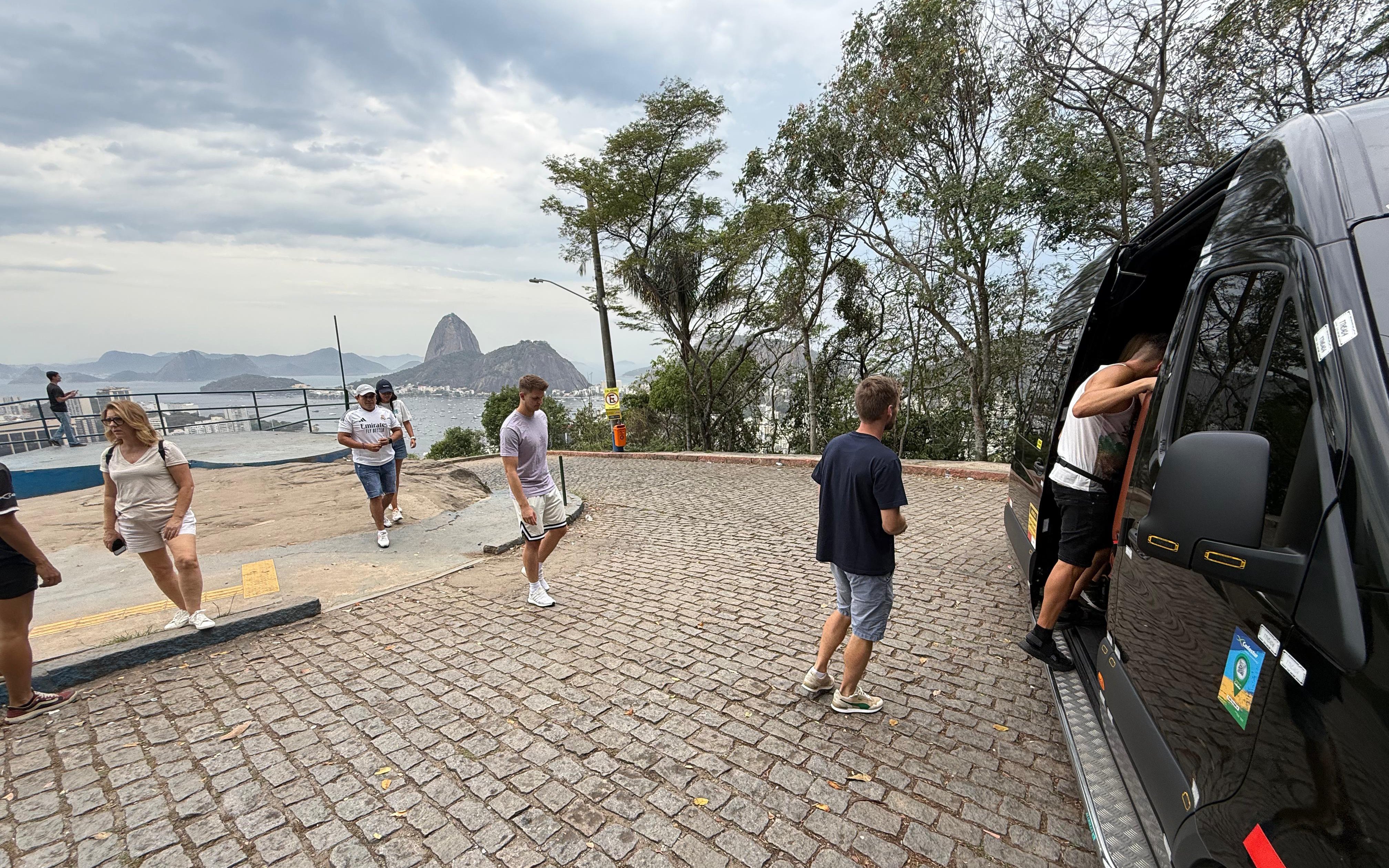 Tourists with guide boarding van at Santa Marta viewpoint, Rio de Janeiro.