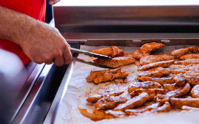 Grilled chicken being prepared on a catamaran cruise near Lérins Island.
