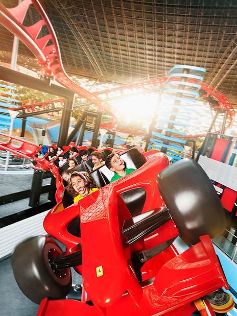 Roller coaster ride at Ferrari World Abu Dhabi with passengers enjoying the thrill.