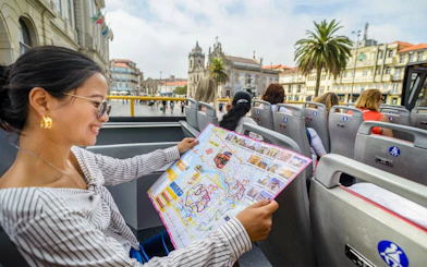 Woman reading map on Porto hop-on hop-off bus tour.