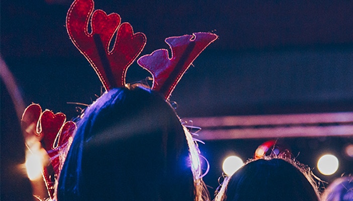 People wearing reindeer antlers at a festive event in Rome during winter.