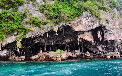Limestone cliffs and turquoise waters at Phi Phi Islands, part of the Phuket full-day tour.