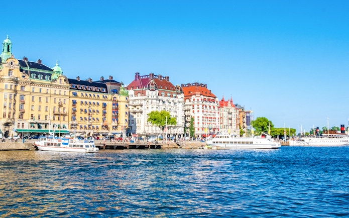 Colorful historic buildings and boats along the waterfront in Ostermalm District, Stockholm.