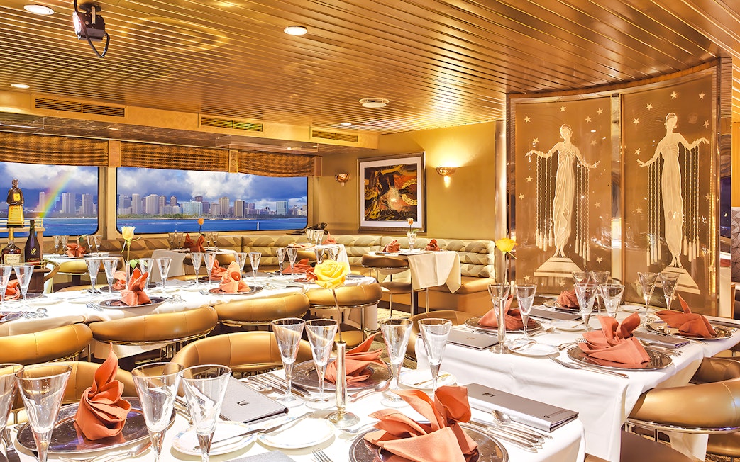 Dining area inside Nova Five Star 2 with elegant table settings and city skyline view.