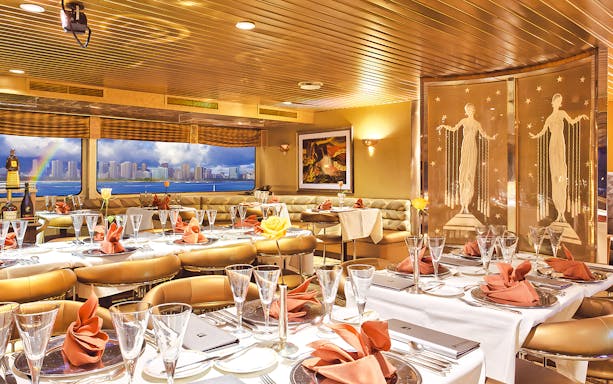 Dining area inside Nova Five Star 2 with elegant table settings and city skyline view.