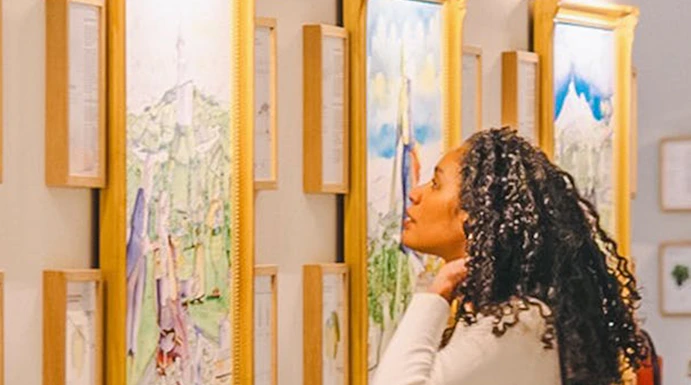Visitor admiring wine-themed artwork in a gallery during The Wine Experience tour.