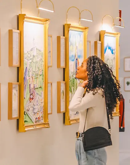 Visitor admiring wine-themed artwork in a gallery during The Wine Experience tour.