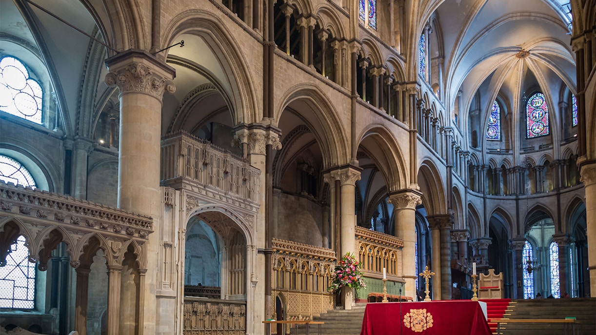 Choir area inside Canterbury Cathedral with ornate arches and stained glass windows.
