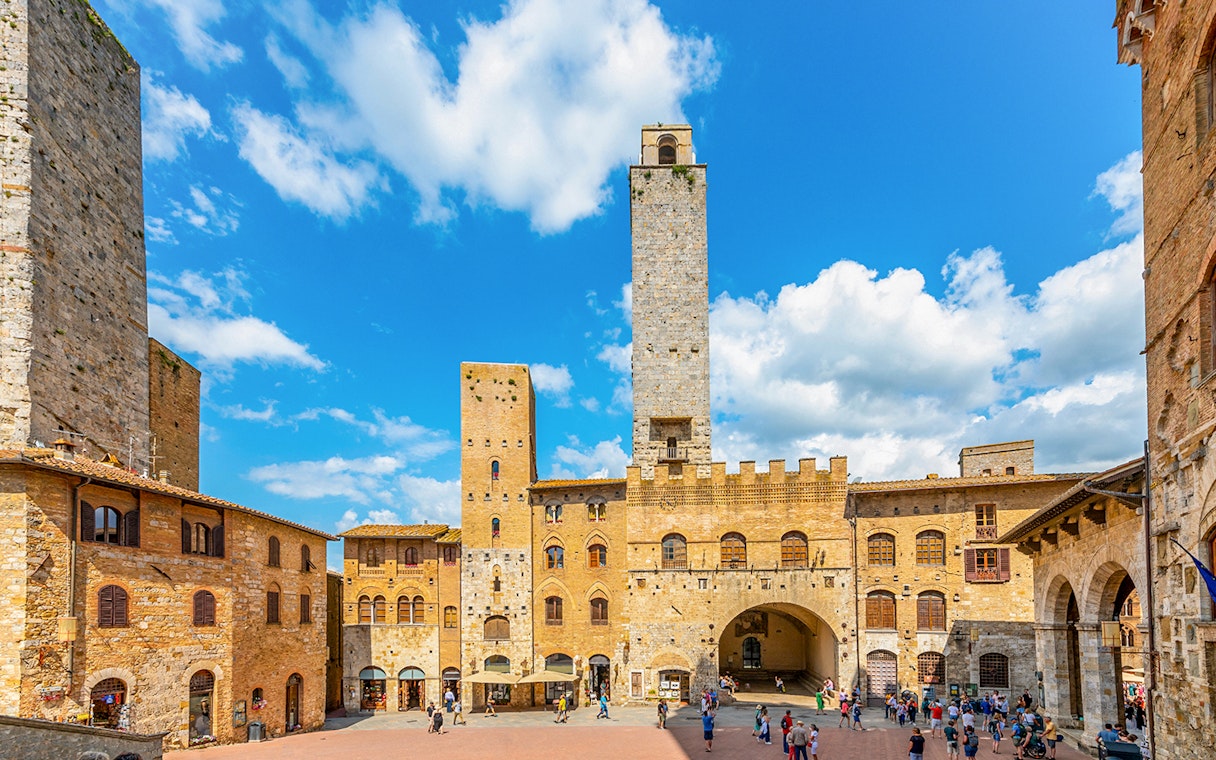 San Gimignano towers and square with visitors, Italy.