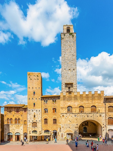San Gimignano towers and square with visitors, Italy.