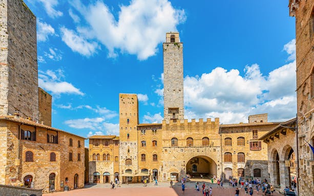 San Gimignano towers and square with visitors, Italy.