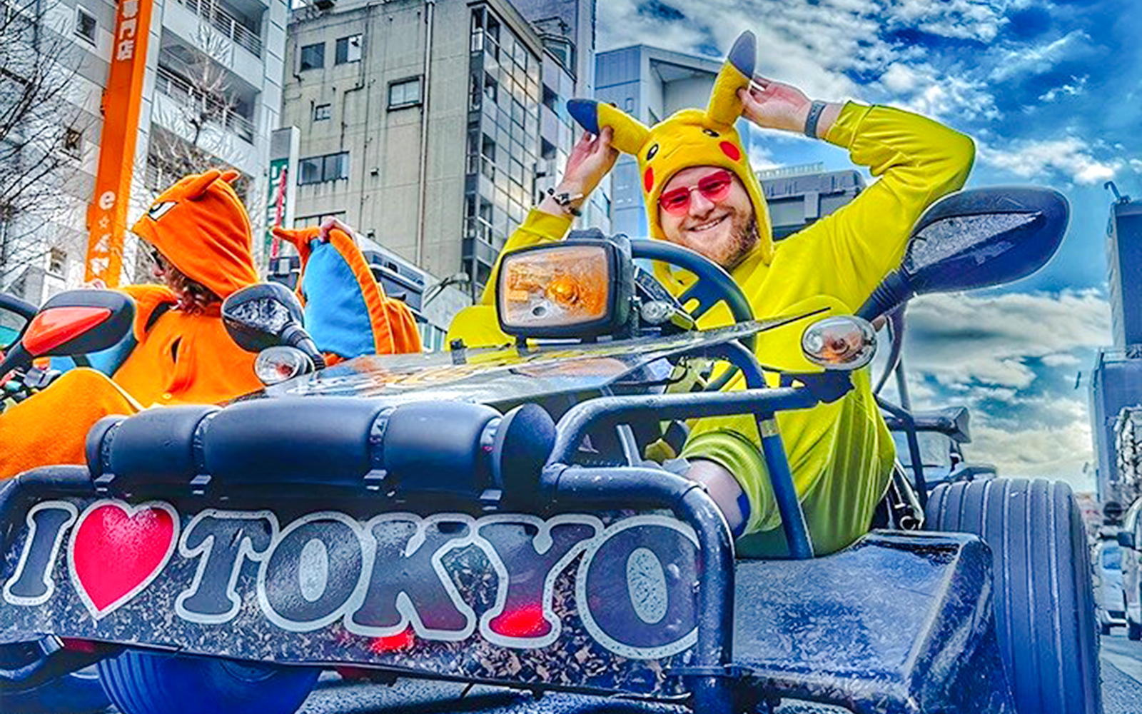 Man in Pikachu costume driving a go-kart in Tokyo street.