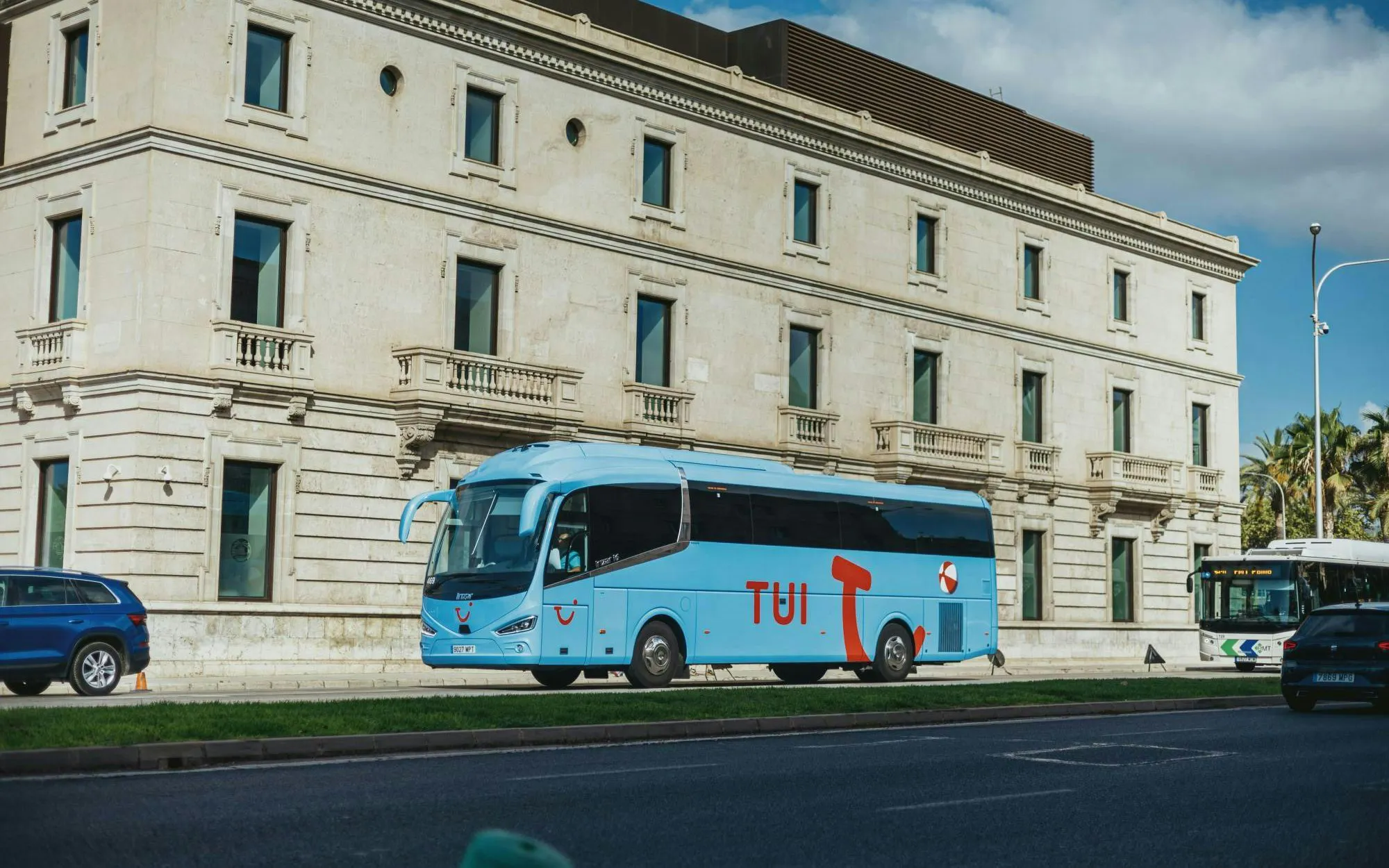 TUI transfer bus parked in front of a historic building.