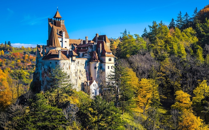 Bran Castle surrounded by autumn trees in Transylvania, Romania.