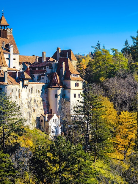 Bran Castle surrounded by autumn trees in Transylvania, Romania.