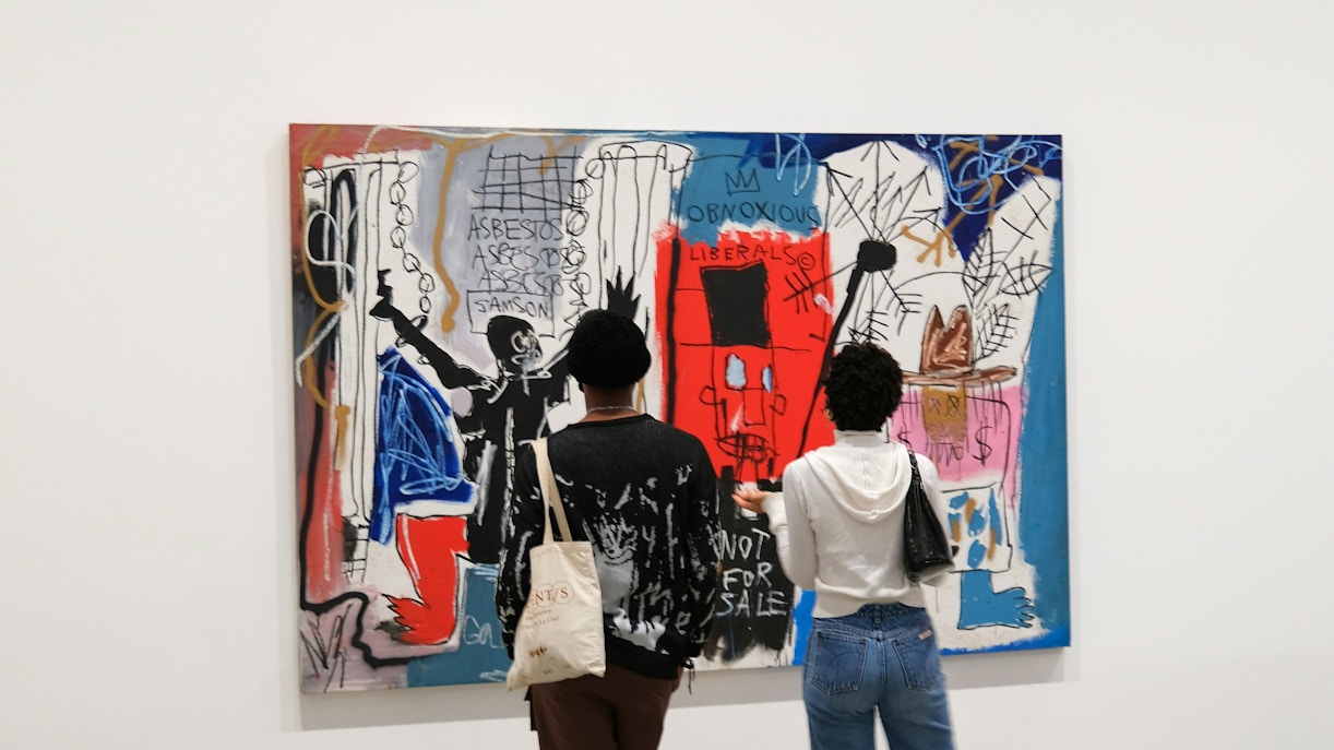 Visitors viewing Jean-Michel Basquiat artwork at Moco Museum.
