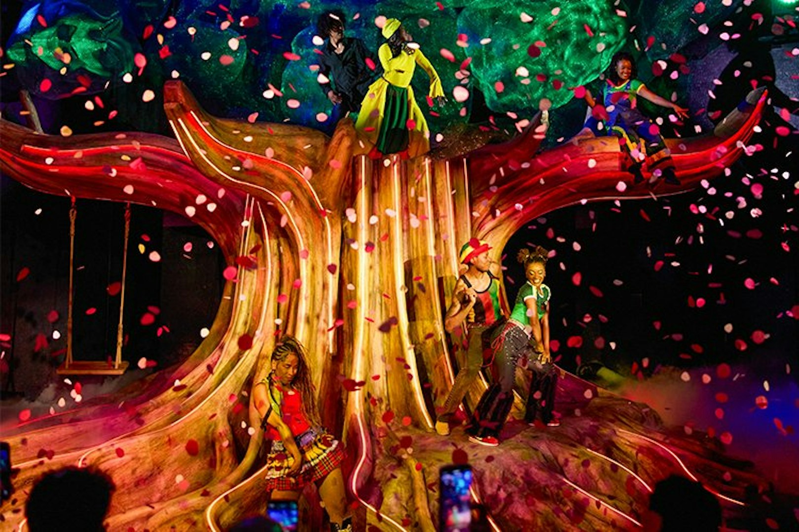 Performers on stage at Bob Marley The Show, Vegas, with vibrant costumes and confetti.