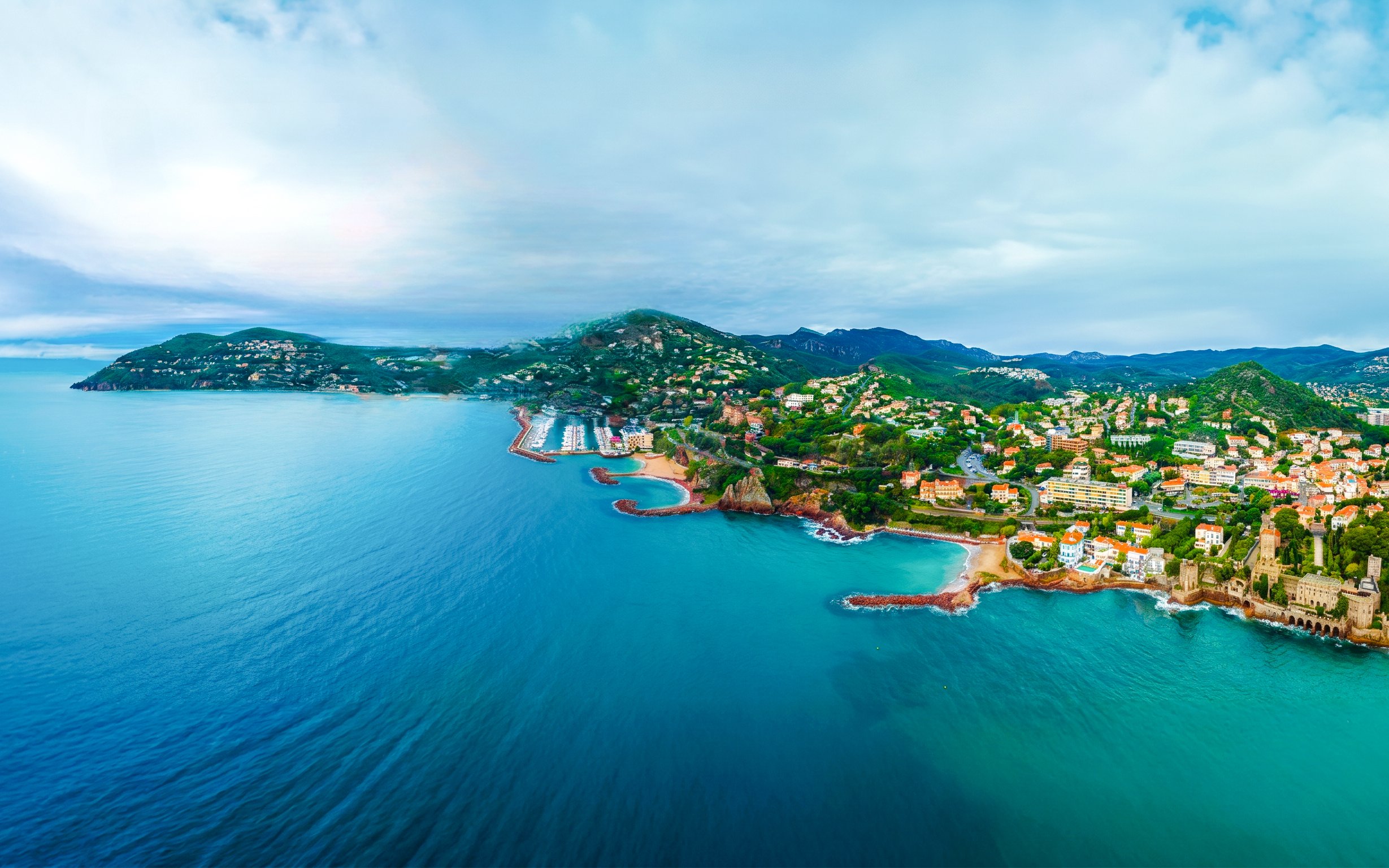 Aerial view of Monaco coastline with lush hills and Mediterranean Sea during a private helicopter tour.