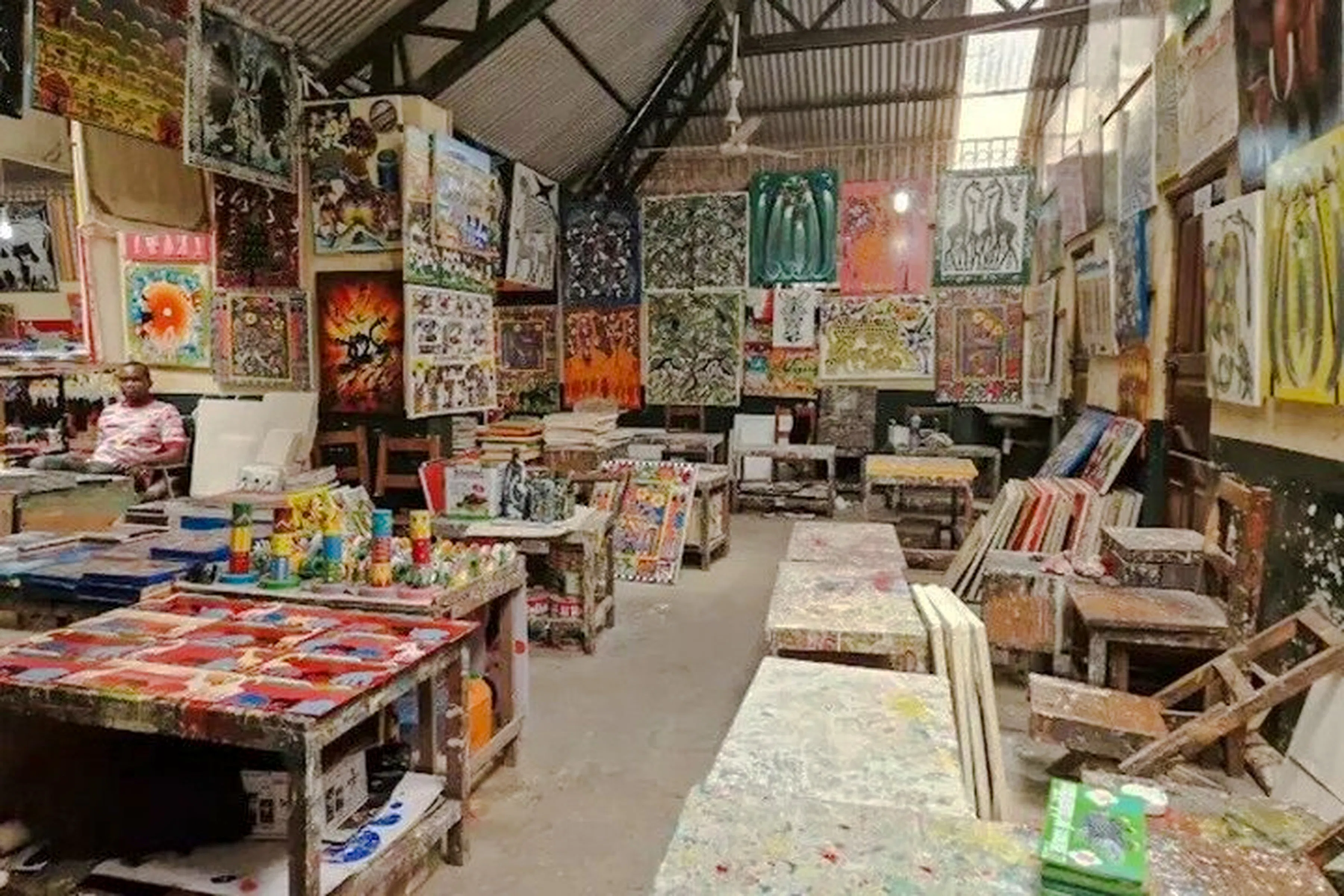 Art market with colorful paintings displayed in Dar es Salaam, part of the Masaki Walking Tuk-Tuk Fish Market & Sunset Tour.