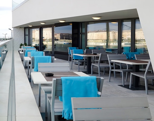 Outdoor seating at a restaurant near Rudas Bath, Budapest, with tables and chairs set for dining.